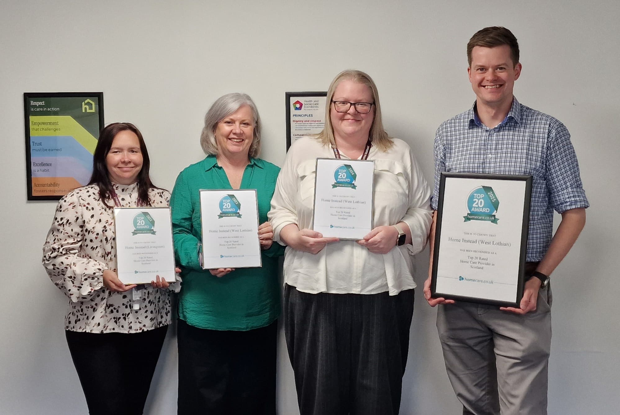 Four people holding awards certificates - Home Instead West Lothian