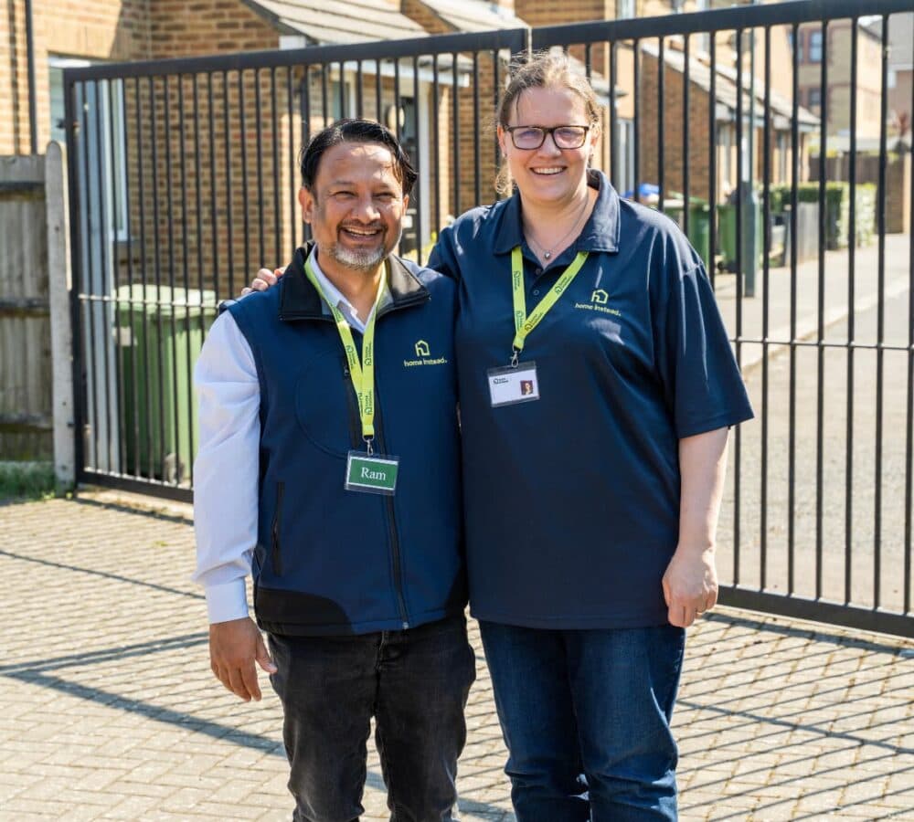A couple standing outdoors both happy and smiling