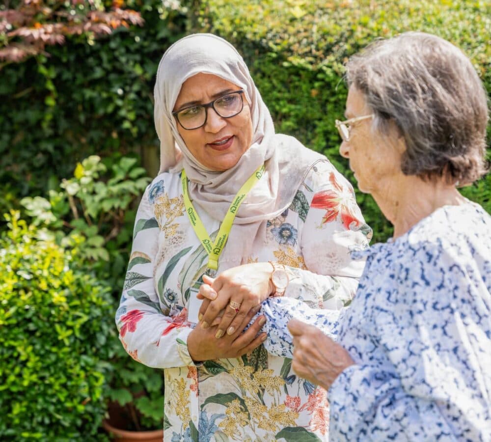 Two women walking together inside the garden