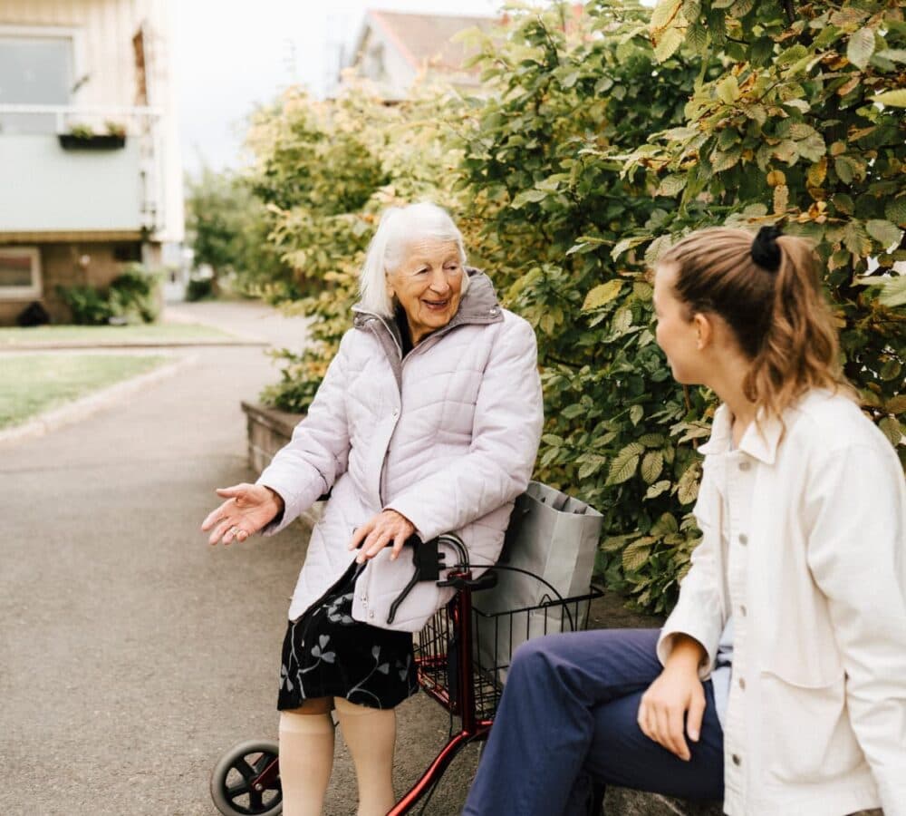 two women happily chatting together outside