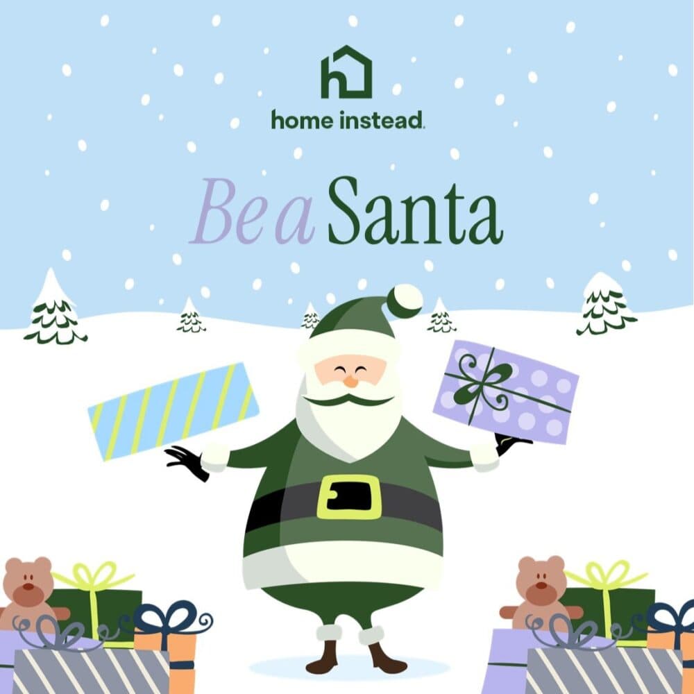 Santa in green holds gifts, surrounded by presents and teddy bears, with snow and trees in the background. - Home Instead