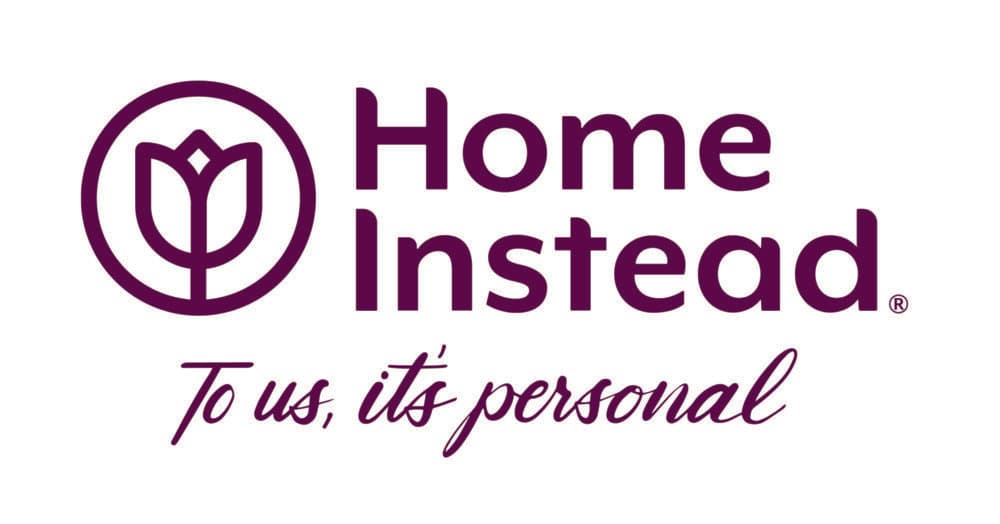 Home Instead logo with a tulip icon and the slogan "To us, it's personal" in purple text. - Home Instead
