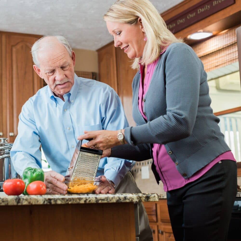 Female live-in carer preparing a meal with her male live-in client