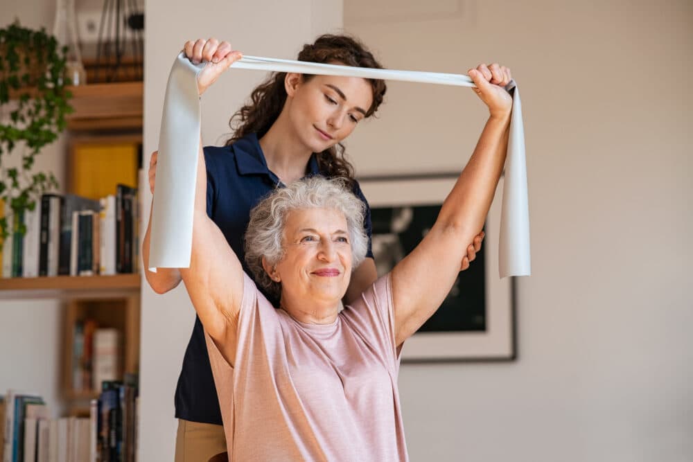 Older lady takes part in seated resistance band exercise