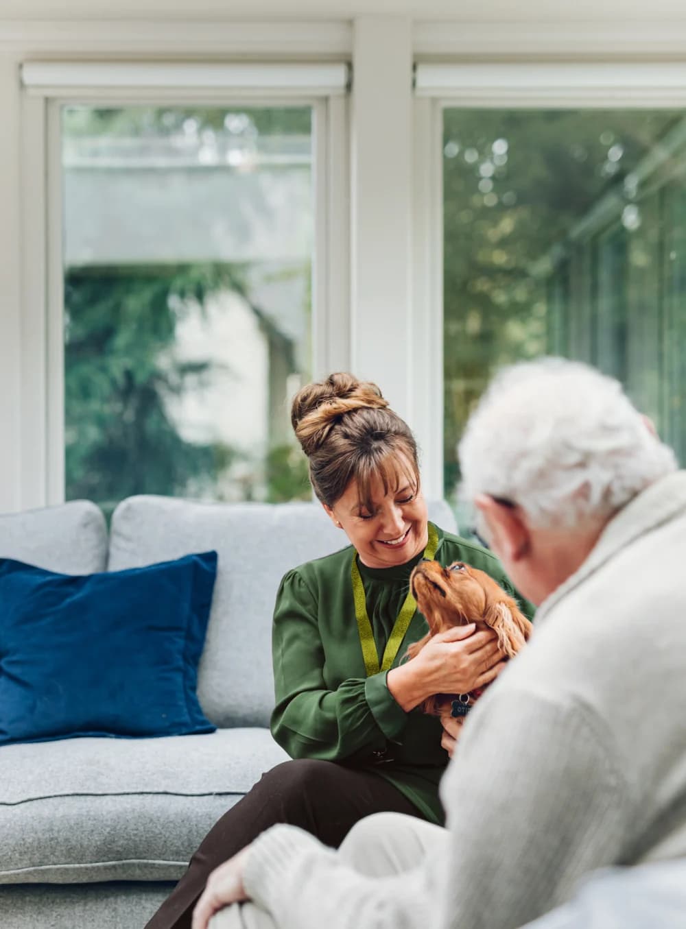 Carer and client sitting with dog
