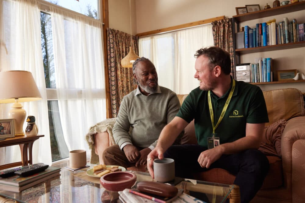 Care Professional and client on sofa.