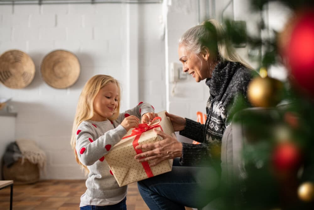 senior lady with dementia unwrapping christmas present