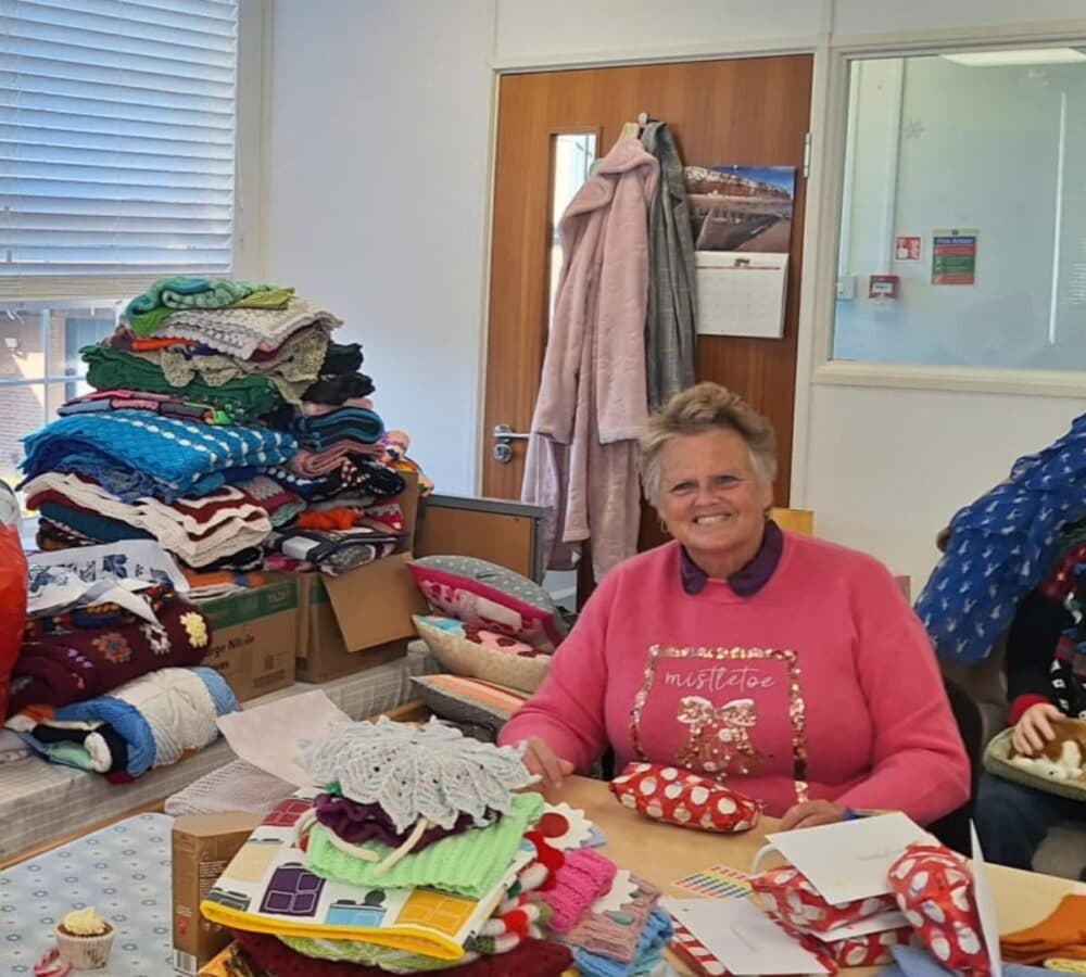 Smiling and happy while wrapping lots of gifts inside the room