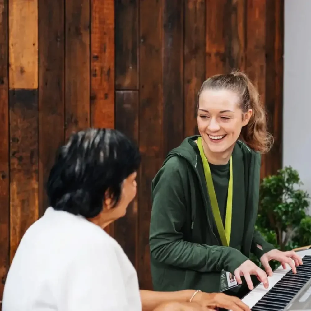 Home Instead Care Professional playing the piano with her client