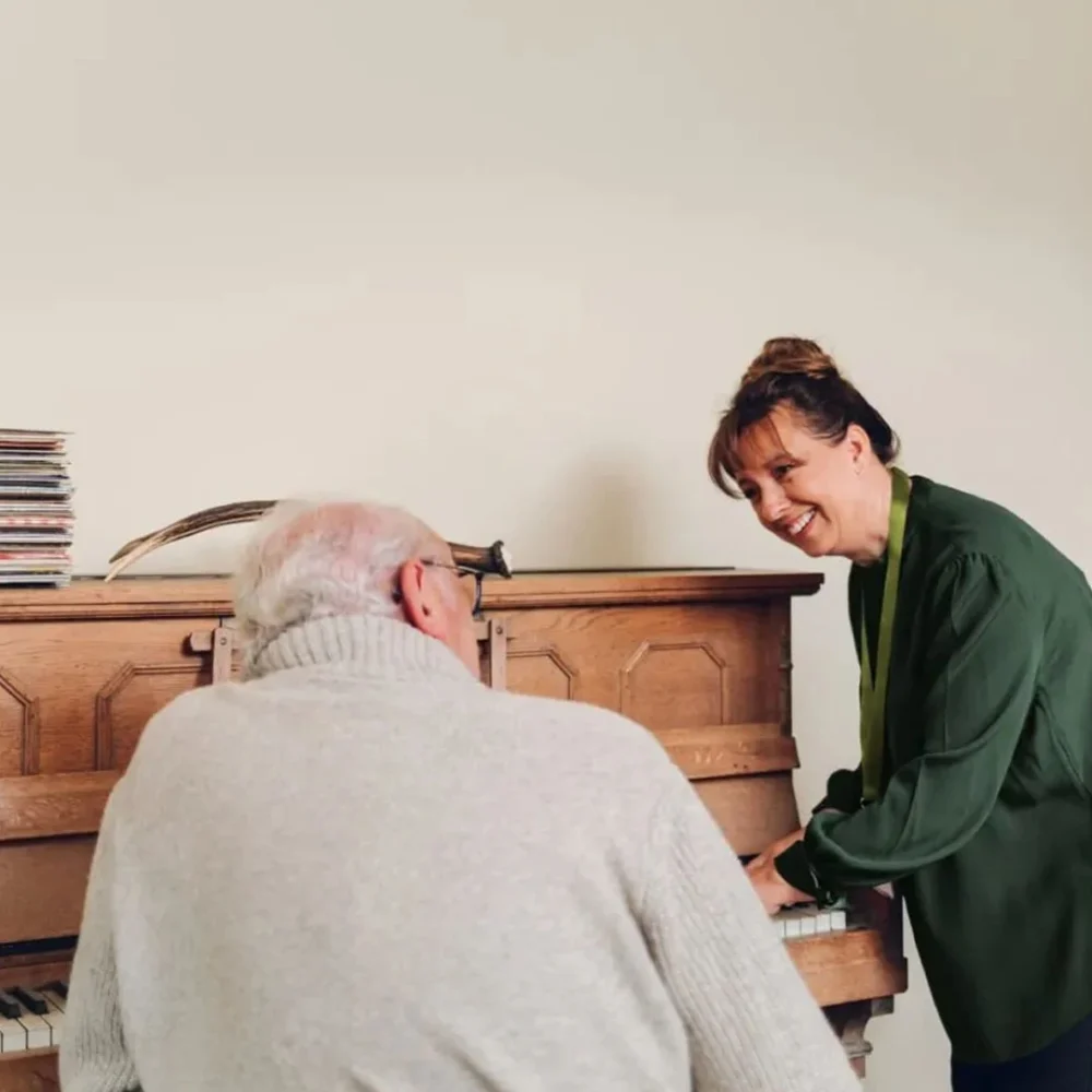 Home Instead care professional playing the piano with her client