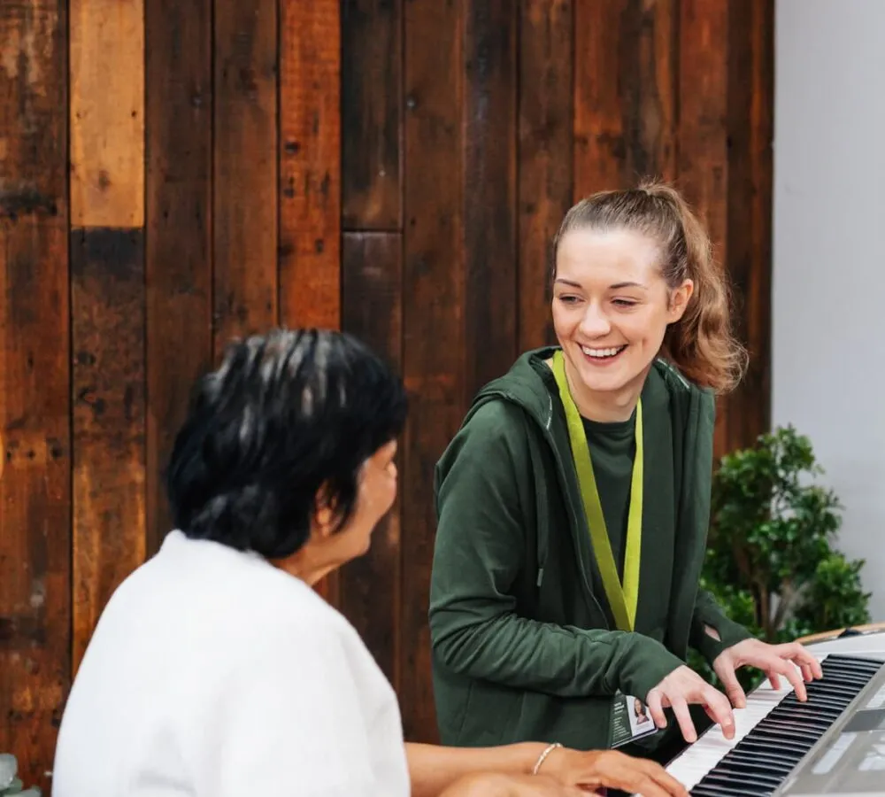 Home Instead Care Professional playing the piano with her client