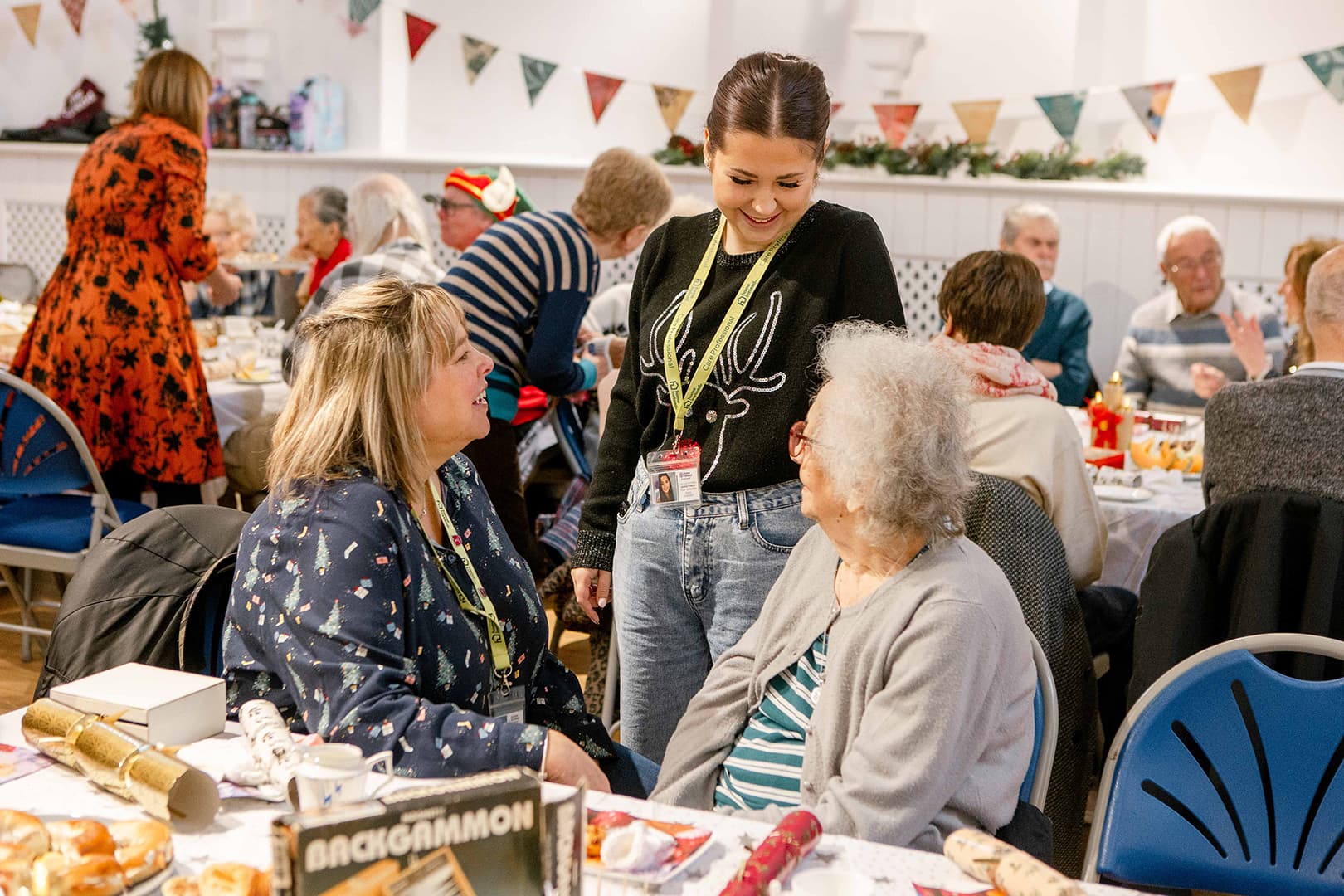 A group of people sitting round a table. - Home Instead