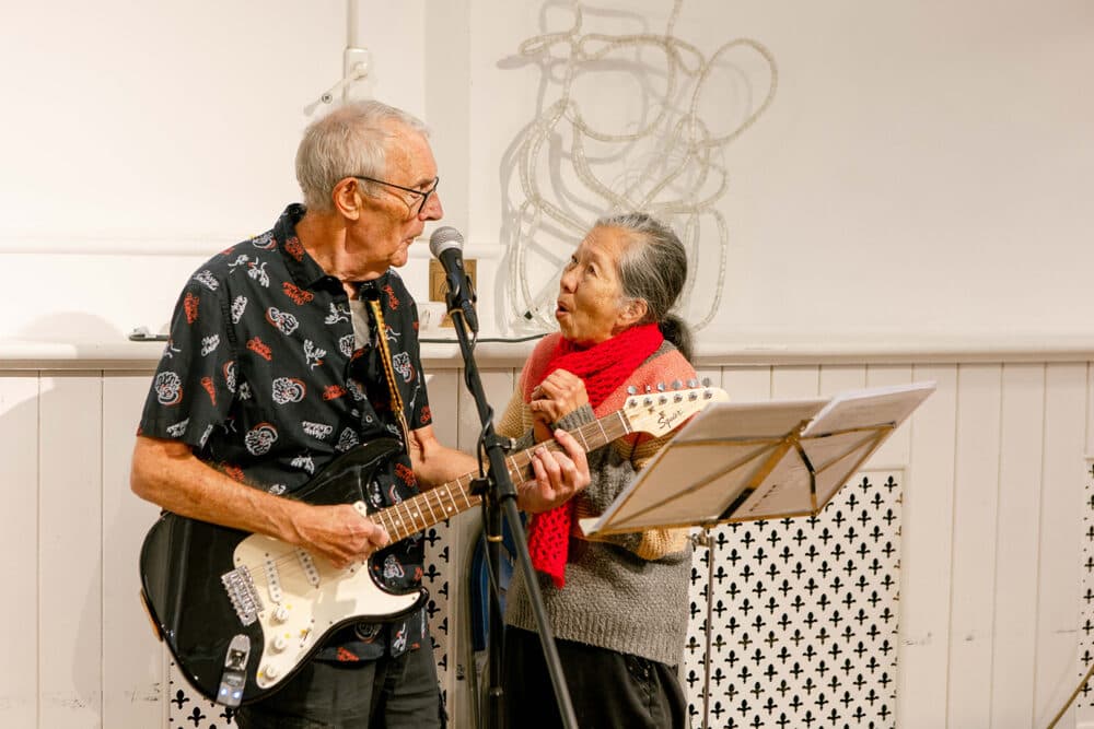 Elderly lady and the event musician singing together at a community event in braintree.