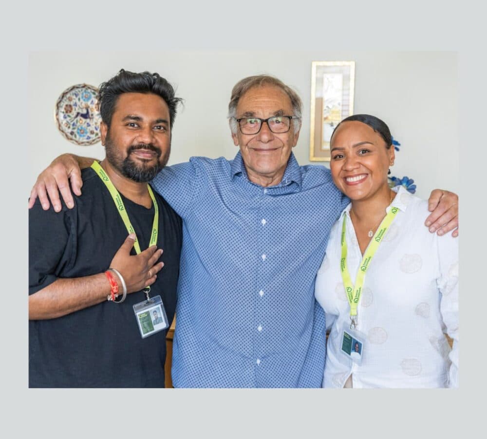Three people standing and smiling and happy inside the room