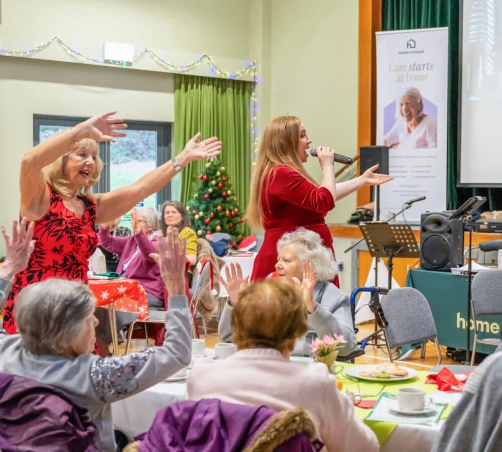 Woman singing and group of people waving their hands