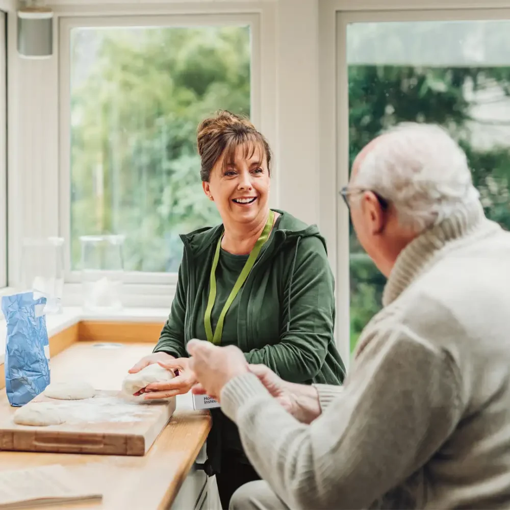 Home Instead Live In Care professional in the kitchen baking with her client