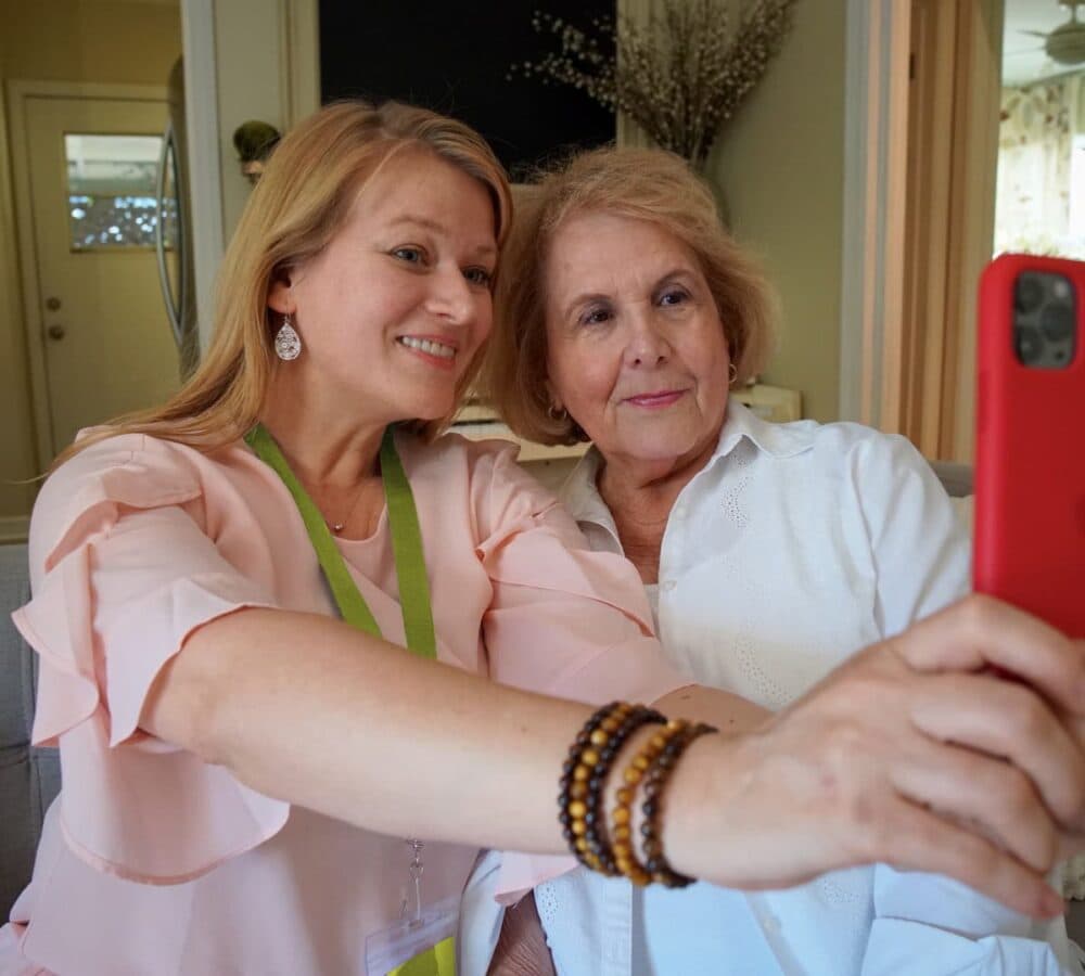 Two women smiling while having their selfie taken inside the house