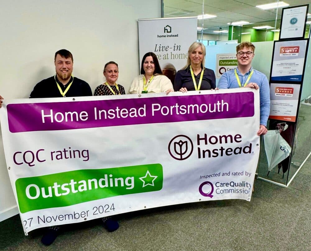 Home Instead Portsmouth team holding CQC Outstanding rating banner
