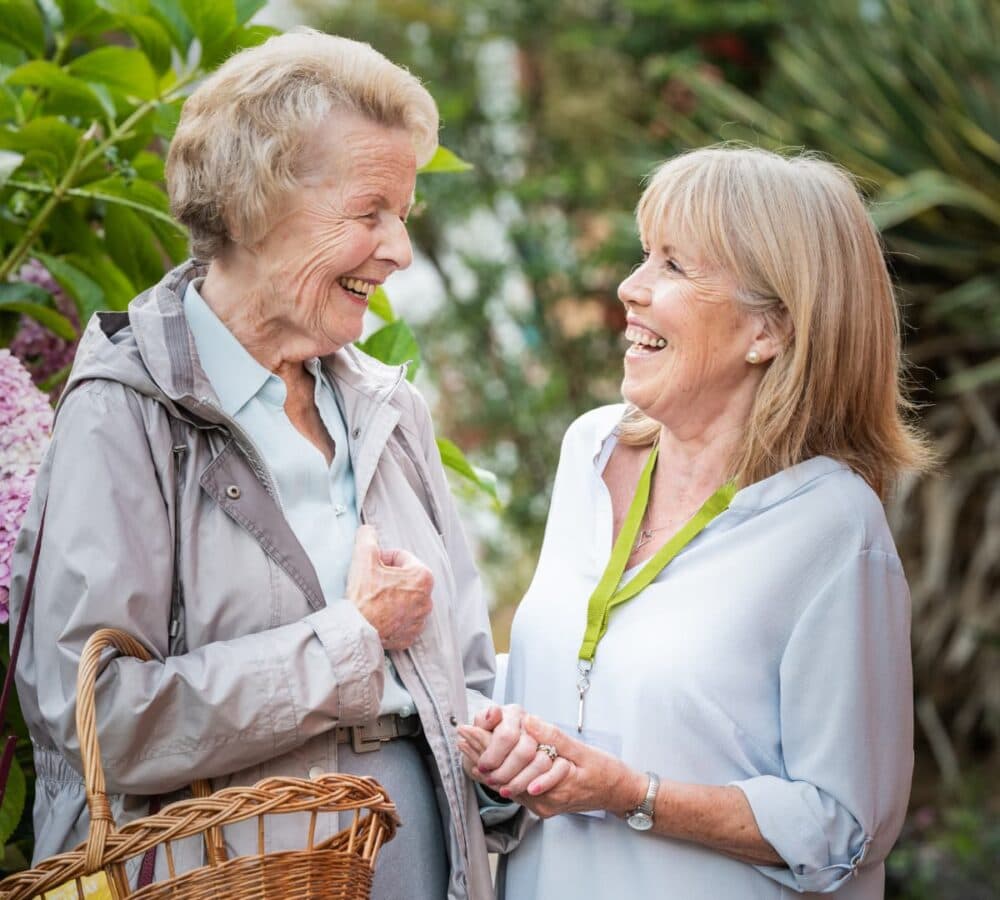 Two women laughing together while enjoying the outdoors
