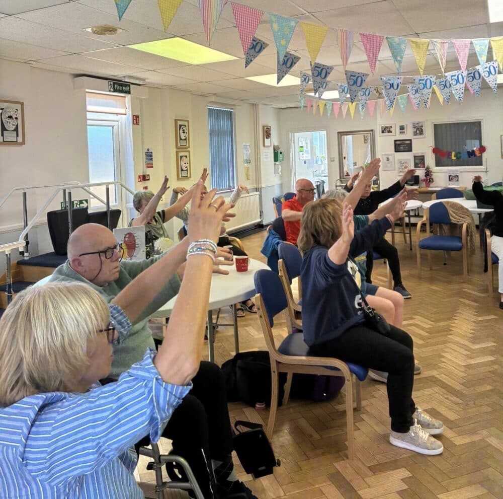 Young Onset dementia group doing seated exercise