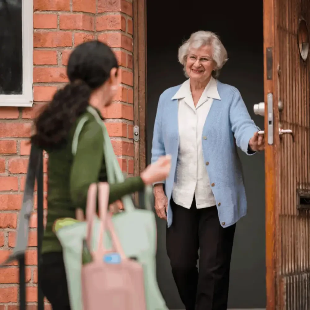 Home Instead Care Professional being greeted by client at the door