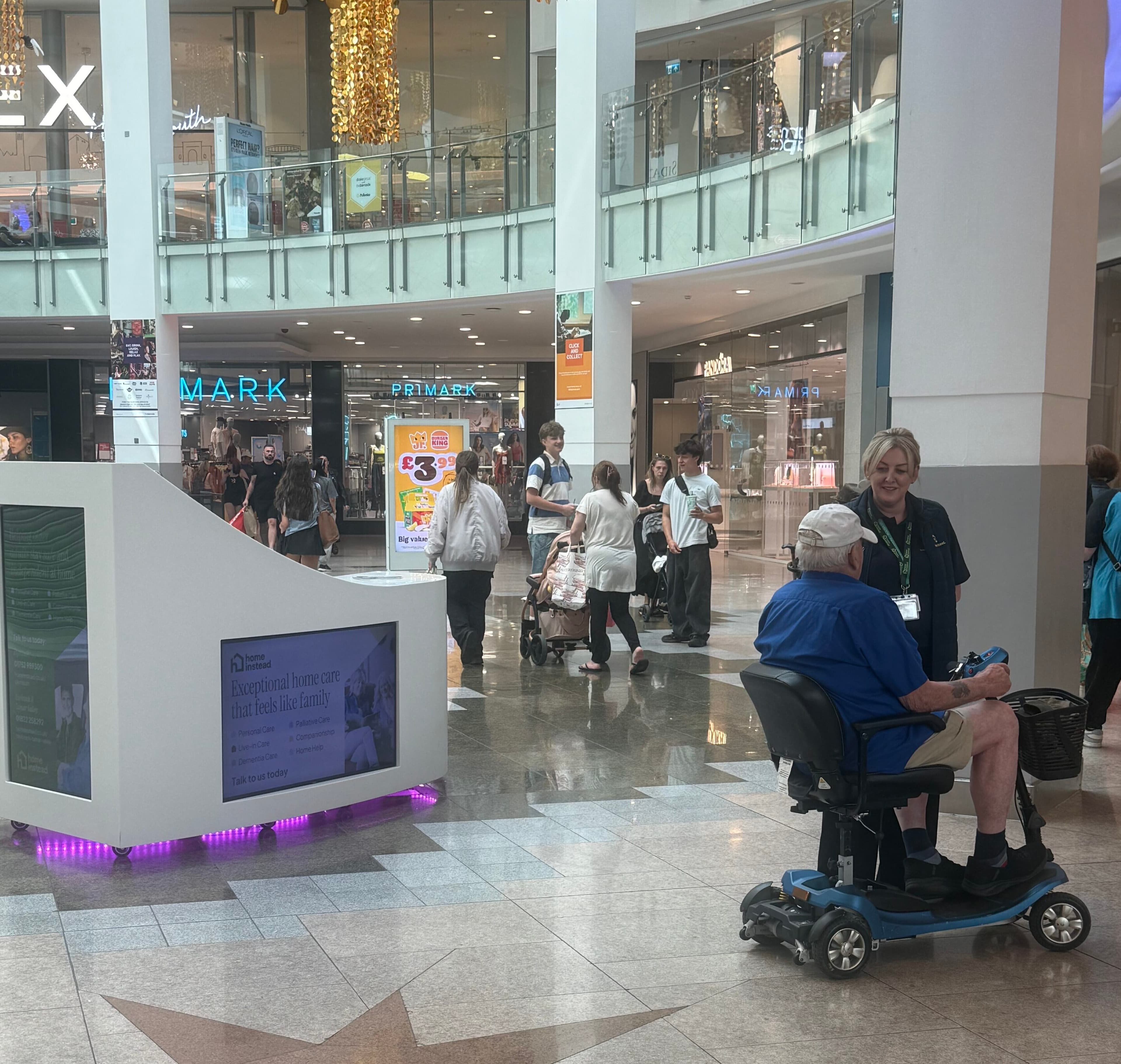 Home Instead Plymouth team member speaking with a local visitor at Drake Circus Shopping Centre community information day