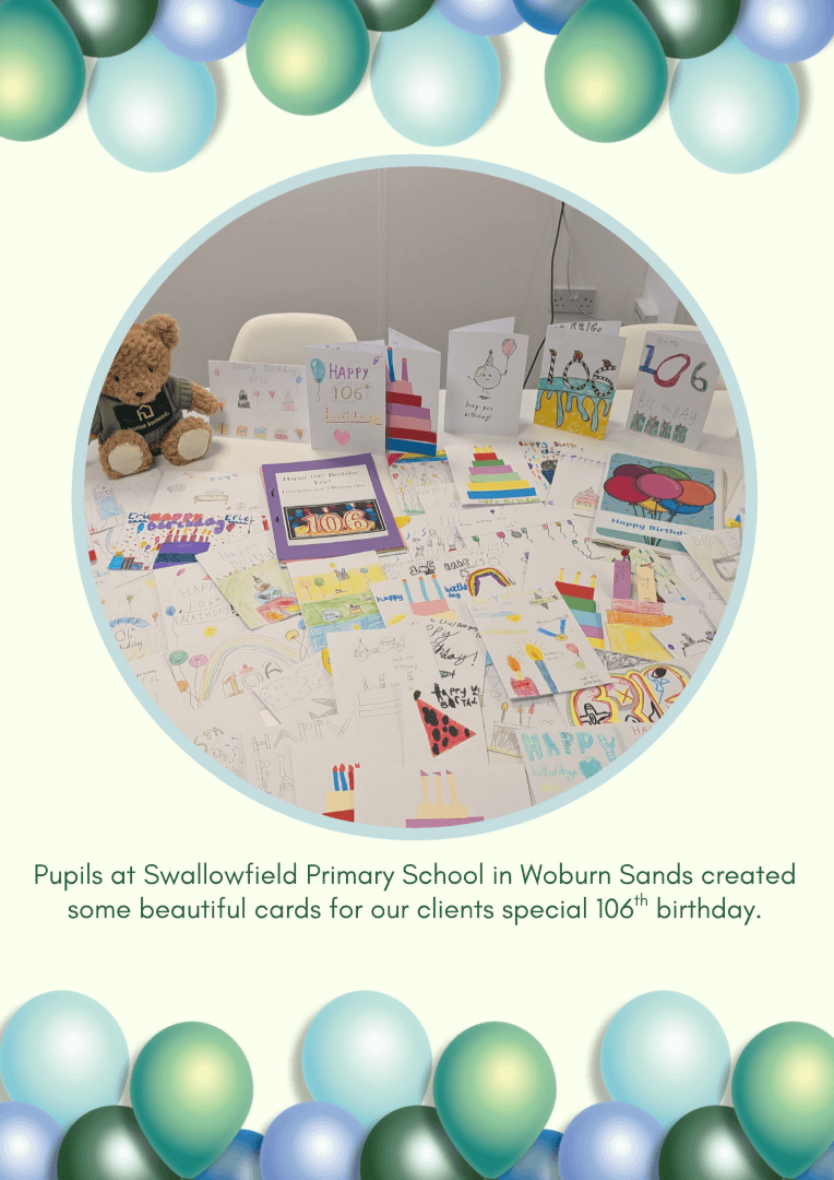 A table covered with colourful handmade birthday cards, a teddy bear, and decorations for a 106th birthday. - Home Instead
