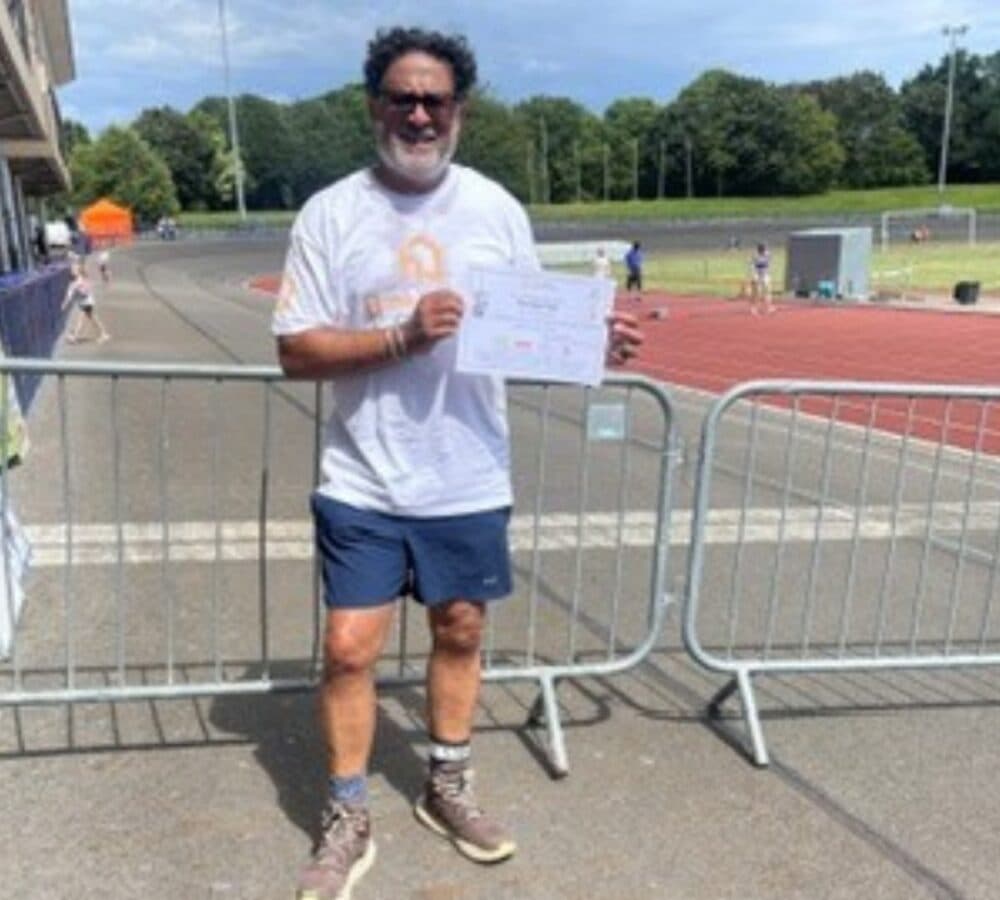 A man standing in the field while holding a certificate