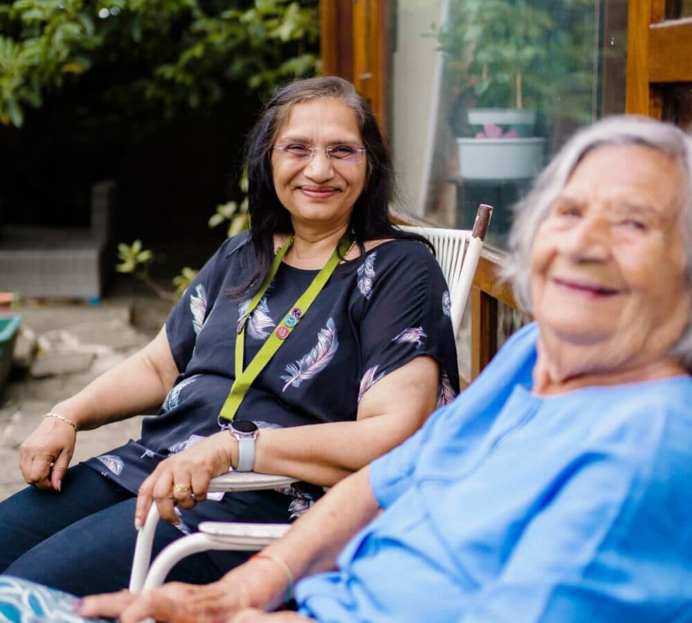 Two women happy and smiling while relaxing in the garden