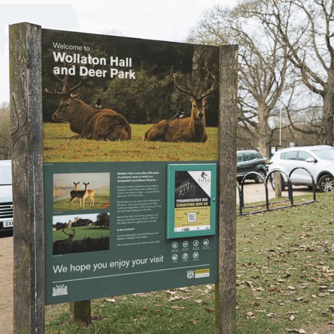 Outdoor sign reading "Welcome to Wollaton Hall and Deer Park," with images of deer and informational text about the park. - Home Instead
