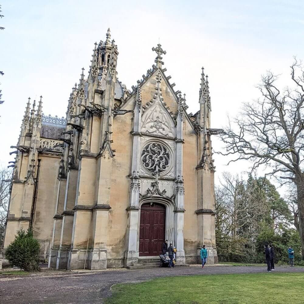 A gothic-style church with intricate designs, tall spires, and an ornate circular window. Sparse trees and people nearby. - Home Instead