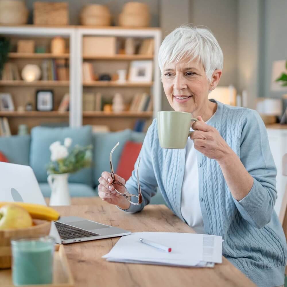lady sitting at a laptop and making written notes