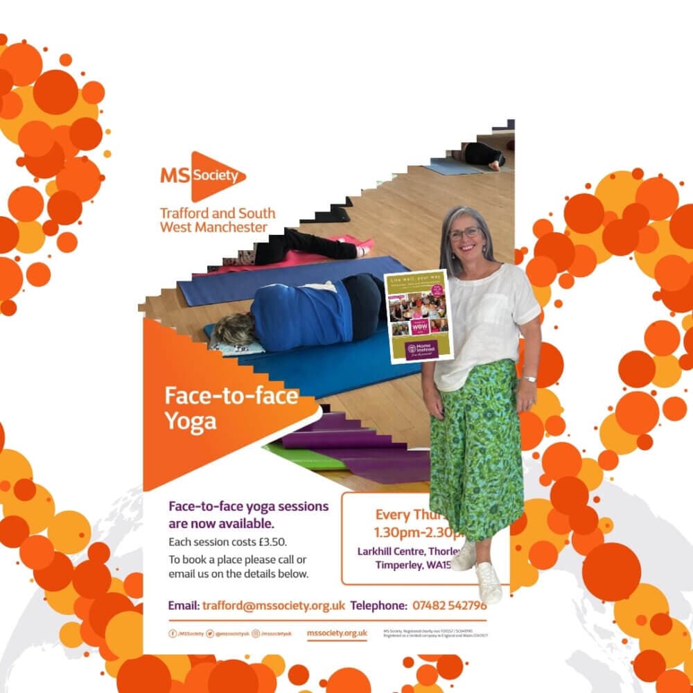A woman stands smiling in front of an MS Society poster about face-to-face yoga sessions in Trafford and South West Manchester. - Home Instead