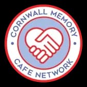 Logo of Cornwall Memory Cafe Network featuring two hands clasped in a heart shape, with a red and blue circular design. - Home Instead