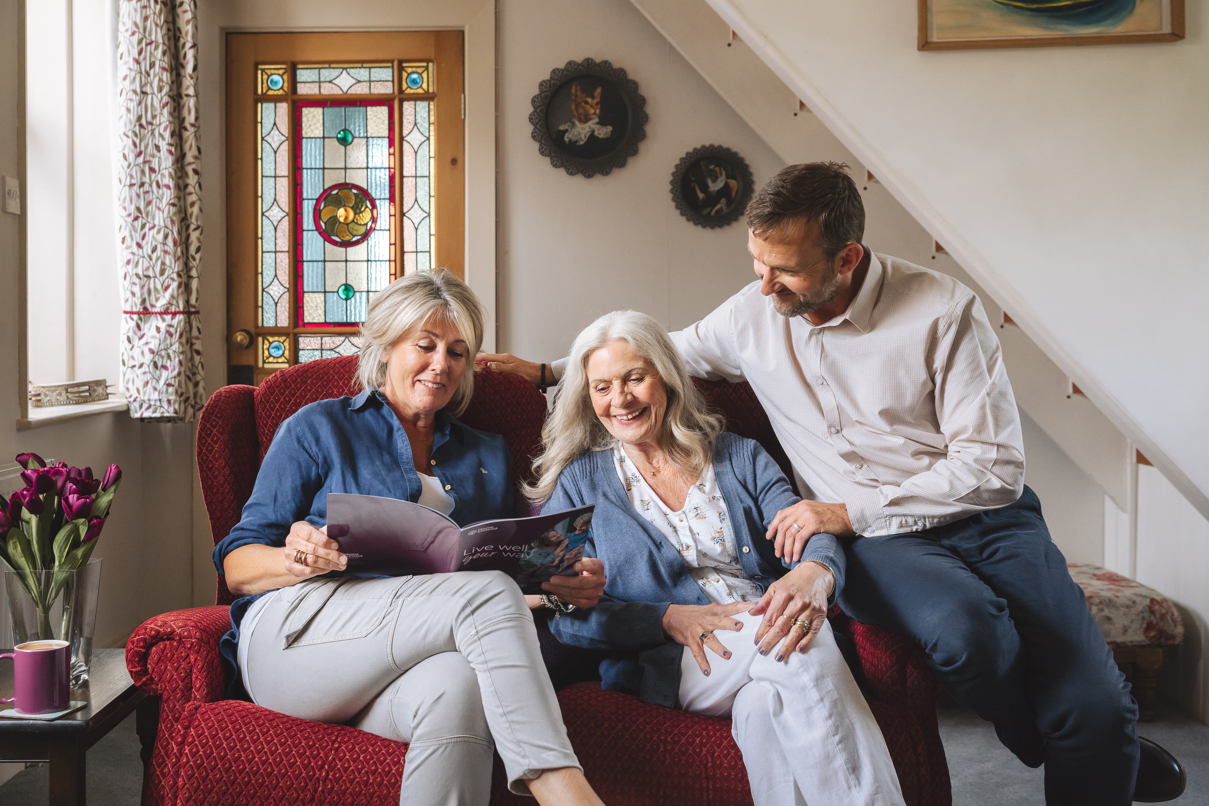 Mother with son and daughter smiling while reading - Home Instead