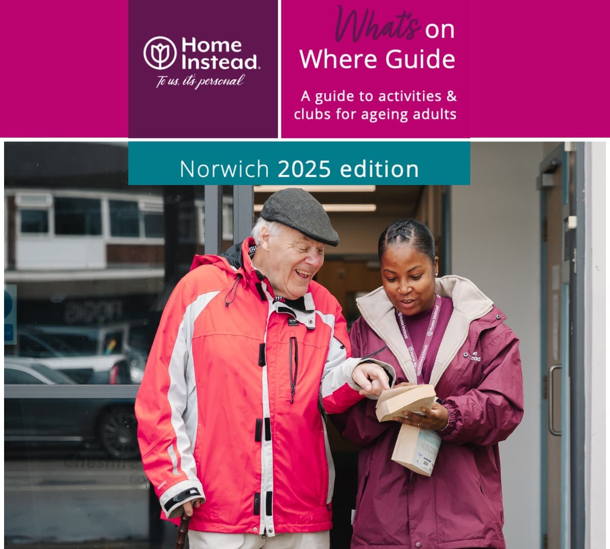 Older man wearing a hat and a sweater walking outside the library while looking at a book with his female carer wearing purple jacket