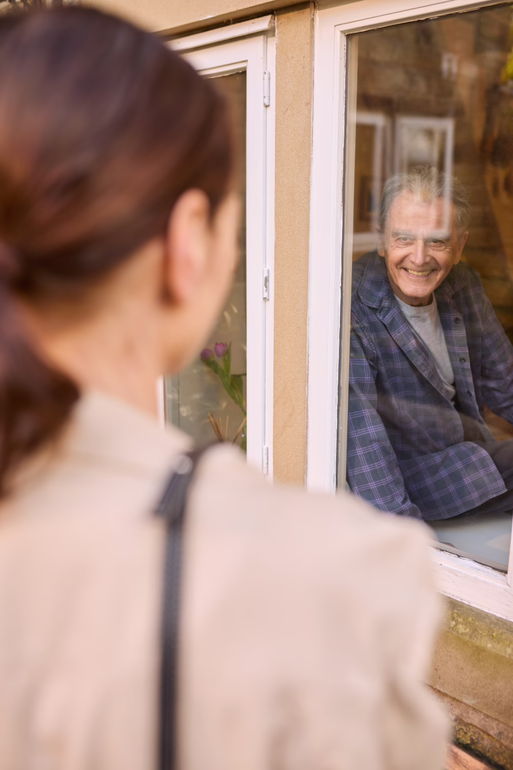 daughter saying bye to the father sitting near the window
