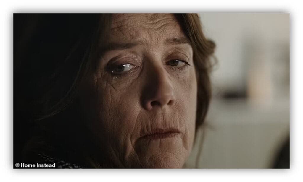 Close-up of a woman with brown hair looking sad and thoughtful, with tears in her eyes. - Home Instead