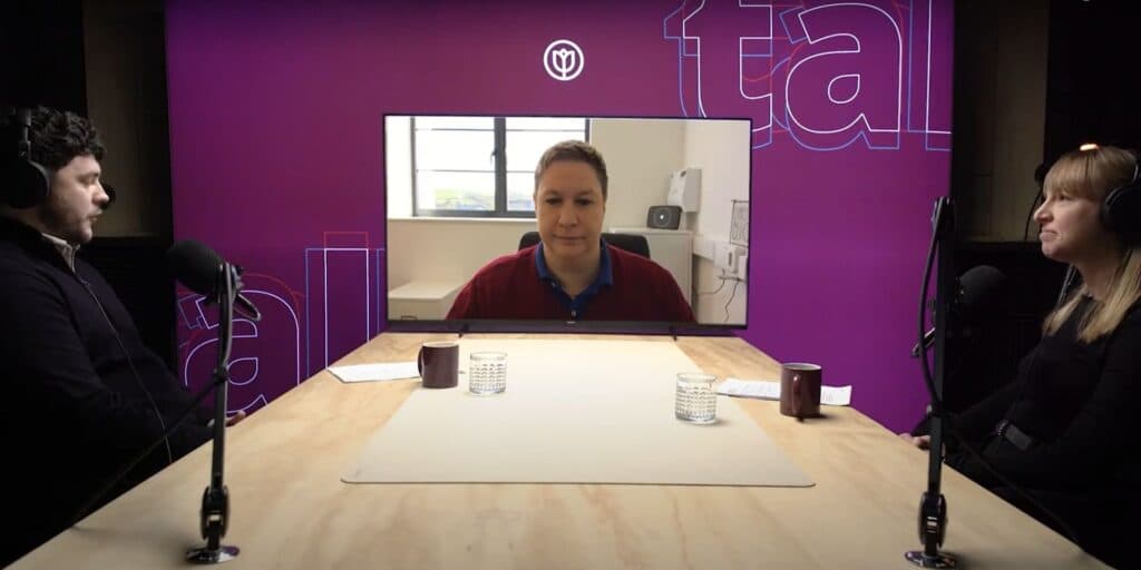Three people record a podcast, two in-studio and one joining remotely, with microphones on a purple set. - Home Instead