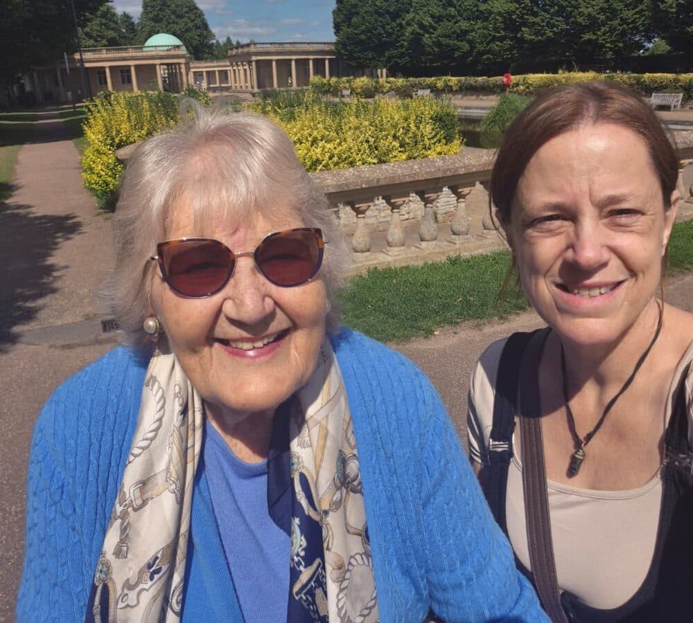 Two women happy and smiling while standing at the park