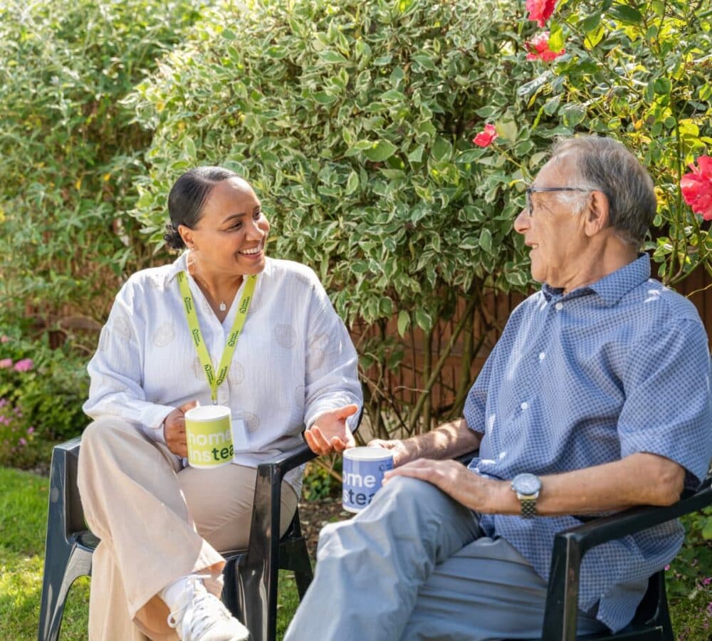 Two women happy and smiling while having coffee in the garden