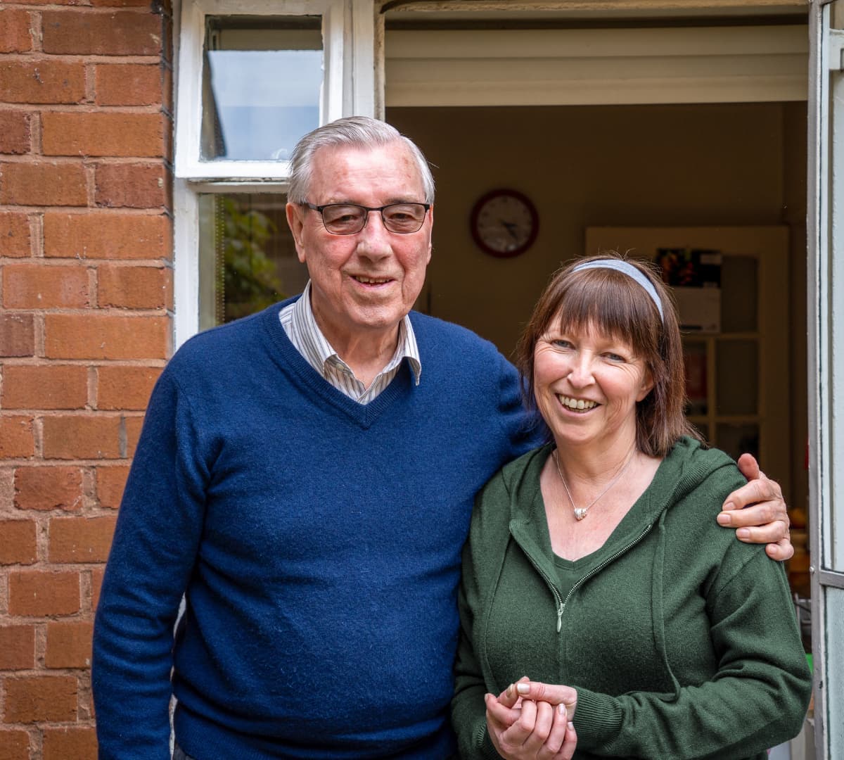 Two people happy and smiling outside the house