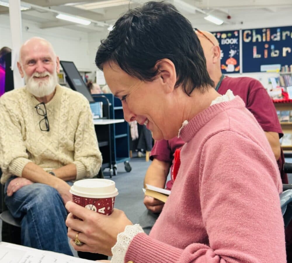 A woman having a coffee and laughing