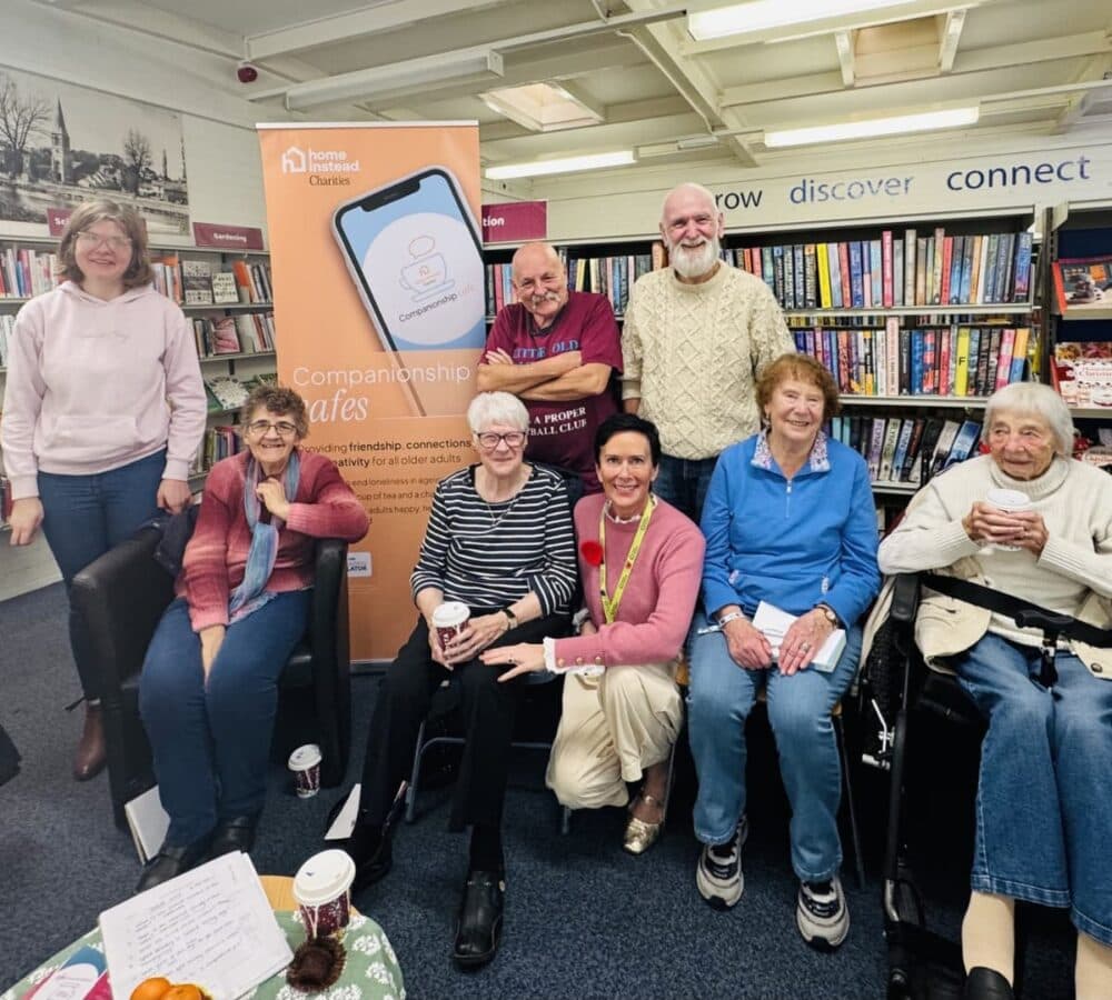Many people sitting and smiling inside the library