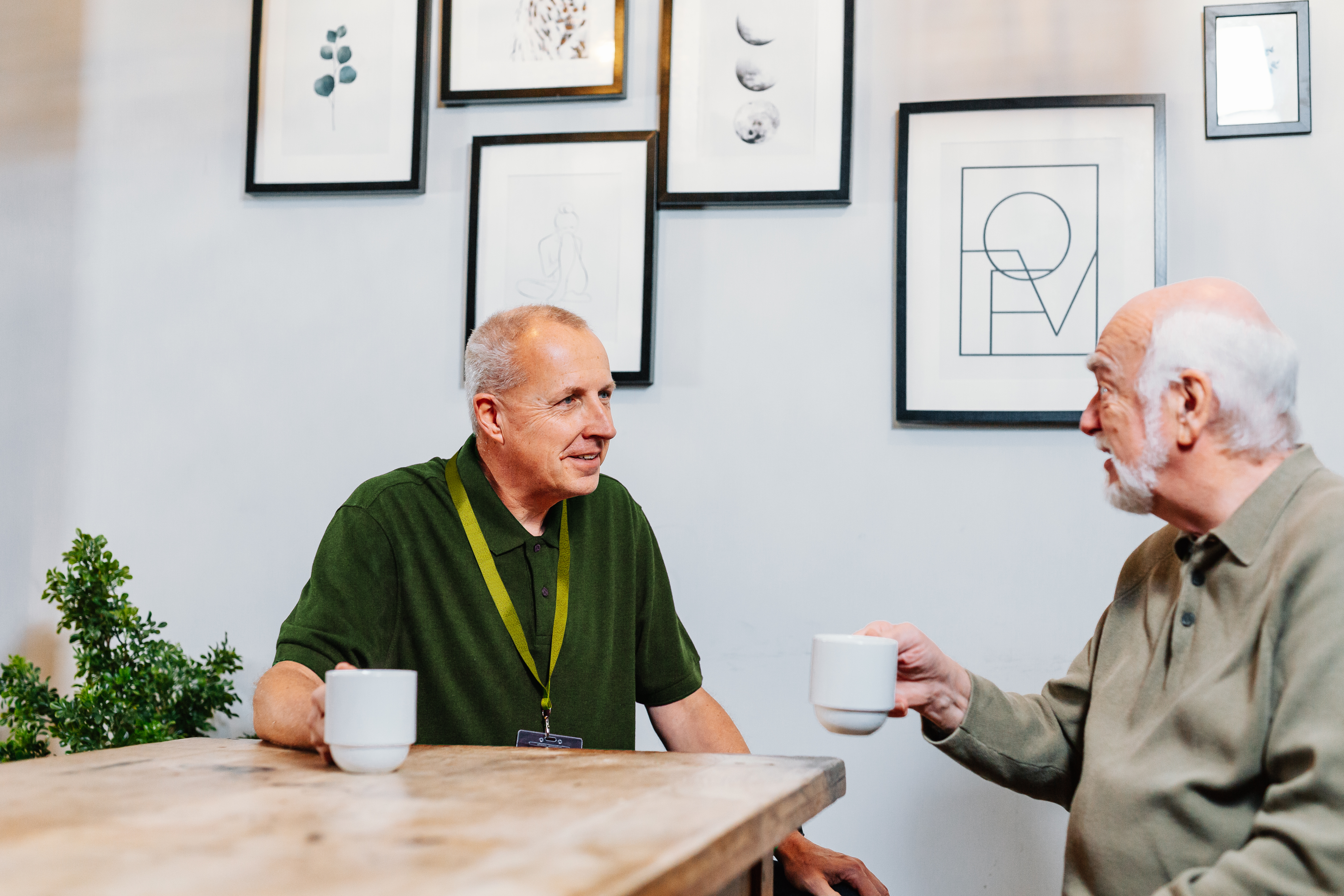 Male Client at home drinking tea with Care Professional - Home Instead