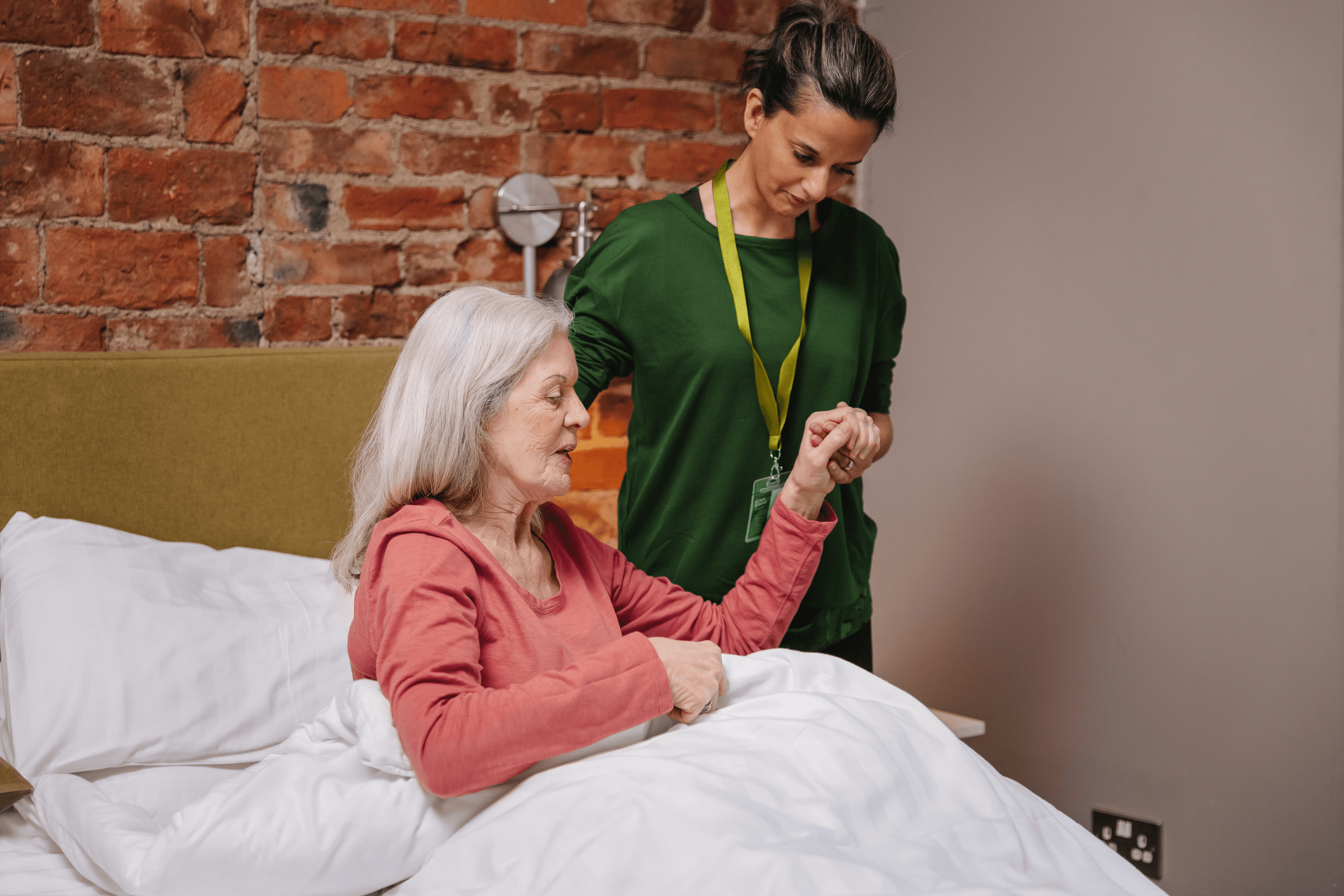 Care Professional helps client out of bed - Home Instead
