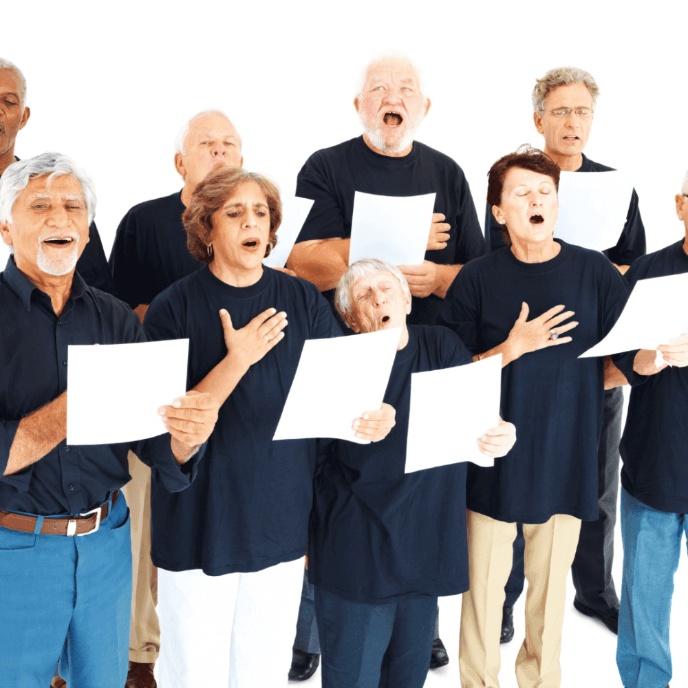 A diverse group of elderly people singing passionately while holding sheets of paper against a white background. - Home Instead