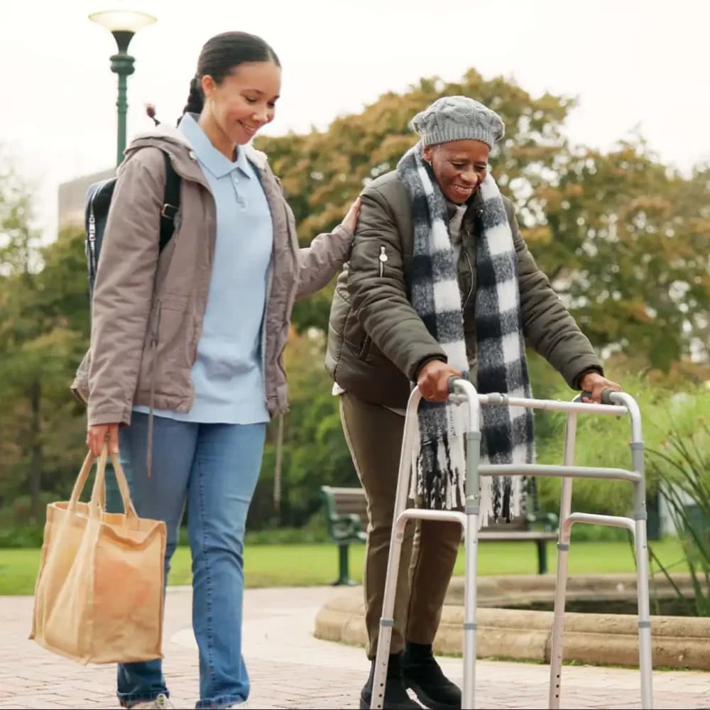 Care professional supporting client outside on a day trip