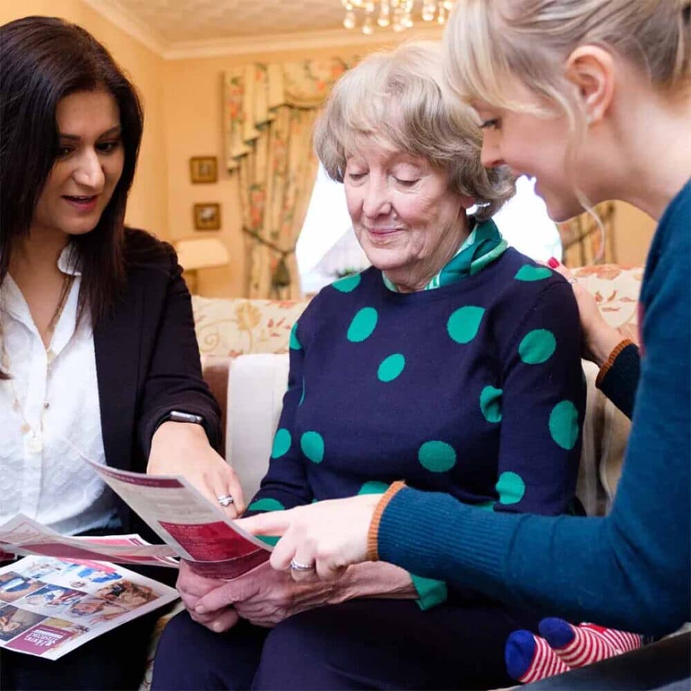 senior lady reviewing care options with her family and a Home Instead care manager