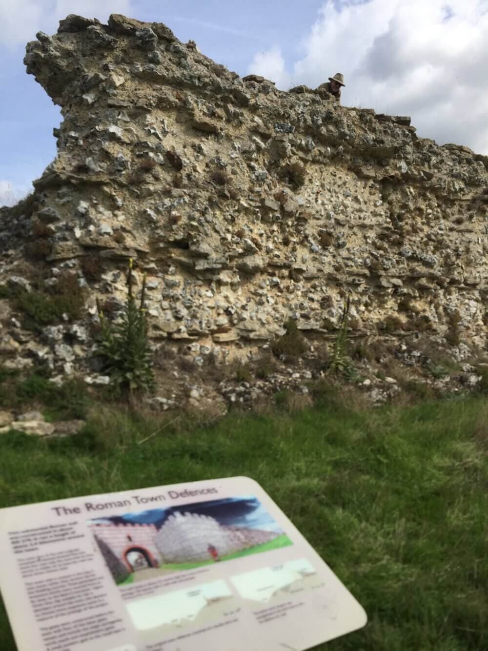 The ruins of the ancient Roman Wall at Silchester, with a visitor's information notice in the foreground